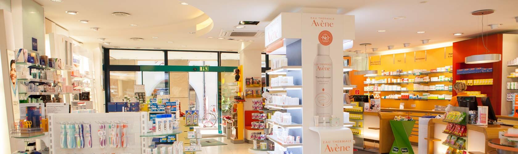 Eine helle Apotheke in Isny zeigt Regale voller Gesundheitsprodukte und Kosmetik im modernen Offizin-Stil.